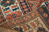 Geometric patterns and multi-colored weft on a hand-knotted antique Kazak rug.