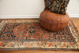 Antique Bijar rug corner with worn fringe, geometric Herati field, and European floral border.
