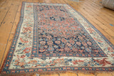 Antique Bijar rug showing dark blue Persian herati field and ivory European floral border.