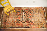Detail of antique Samarkand runner, highlighting textural wear and geometric patterns in orange, black.