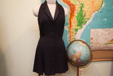Vintage Betsey Johnson black dress, showcasing button-down front and pleated, short skirt.