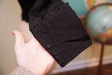 Textured black fabric and three small buttons on the antique Edwardian bodice cuff.
