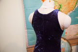 The scooped back and central seam of a deep purple vintage velvet dress.