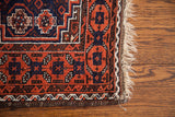 Vintage Tribal Belouch rug corner, rich madder red and indigo geometric patterns, with fringe.
