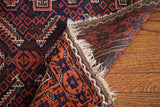 Folded Belouch tribal rug: madder red, indigo blue geometric design and secure fringe.
