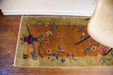 Vintage Art Deco rug featuring deep mustard gold field, lime green border, and flowering vase design.