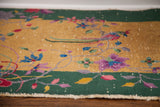 Art Deco Chinese rug with vibrant floral motifs, deep gold field, forest green border, exposed white knots.