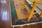 Art Deco Chinese rug corner: red butterfly, green border, gold field, exposed knots.