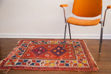 Bright cheerful vintage Turkish rug with vibrant geometric patterns and a red field.