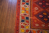 Vintage Turkish rug's geometric border with tangerine, saffron, indigo, and cherry red, showing end loss.