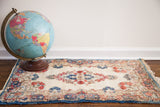 Vintage Kerman rug mat with off-white field and rose, indigo floral patterns, 1'10