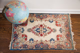 Vintage Kerman rug showcasing central tone-on-tone rose and multi-tone indigo Persian floral details.