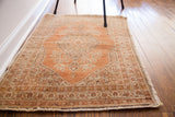 Intricate earthen-toned border and soft rust field detail of the vintage Tabriz rug.
