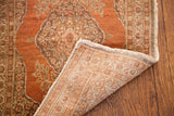 Vintage Persian Tabriz rug corner showing rust floral pattern and intricate hand-knotted foundation.