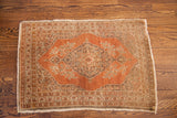 Detailed central medallion of a vintage Persian Tabriz rug in rust and earthen tones.