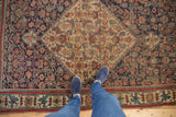 Fine weave antique Bijar rug showcasing traditional central medallion in indigo blue, red, and saffron.