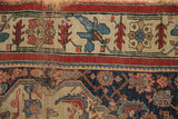 Antique Bijar rug detail with indigo and red stylized patterns, cream border, showing wear.