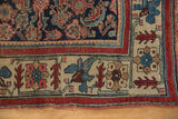 Corner of antique Bijar rug with stylized floral borders, dark blue field, red and saffron tones.