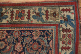 Antique Bijar rug corner: finely knotted indigo field, red border, saffron geometric motifs.