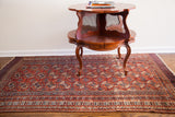 Vintage Tekke Bokhara rug with repeating terracotta red gul motifs and geometric borders, 4'6