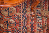 Terracotta red, navy, and tan geometric gul patterns on this vintage Bokhara rug.