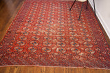 Antique Tekke Bokhara rug, warm red and deep blue, displaying rhythmic style and nuanced age-related wear.