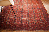Antique Tekke rug with rich red Bokhara guls, showcasing rhythmic design and visible wear.