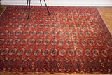 Red, navy, cream Bokhara guls and geometric border on antique Tekke rug with wear.