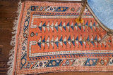 Detail of a Vintage Pink Turkish rug's geometric border and blue double tree design.