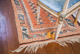 Fringed corner of a vintage Turkish Melas rug featuring blue and pink geometric double tree motifs.