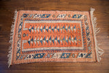 Vintage Turkish Melas rug corner with peach field, blue geometric border, and white triangular patterns.