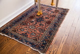 Vintage Hamadan rug border detail, with indigo snail shell vines and frayed edge.