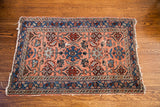 Traditional Persian Hamadan rug, light rose field, indigo border, allover palmette design, visible end loss.
