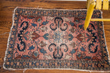 Persian Lilihan rug upper corner: rose field, navy cloudband motif, blue floral vines, worn edge.