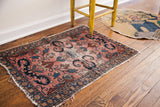 Vintage Persian Lilihan mat pattern with cloudband motif, blossoming vines, and tattered edges.