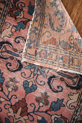 Vintage Persian Lilihan rug fold: light rose floral pile, distressed ends, visible foundation weave.