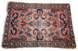 Tattered corner of vintage Lilihan rug showing rose field, blue floral vines, and geometric border.