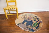 Whimsical Chinese rug detail with cottage, tree, clouds, plum and teal colors, frayed edge.