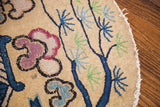 Whimsical tree motif with navy, lime, plum on the vintage Chinese rug's worn edge.