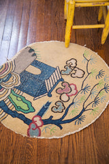 Whimsical blue cottage with green tree and soft pink clouds on vintage round rug.