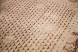 Soft aged ivory field with recurring burgundy motif of a traditional Turkish rug.