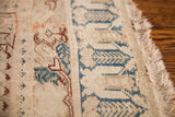 Aged ivory field with nuanced blue and burgundy geometric patterns on a collectible Turkish rug.