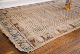 Antique Turkish rug corner with unique teal border and aged ivory field.