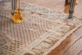 Aged ivory field with repeating burgundy motif, subtle blue border, and delicate edge.