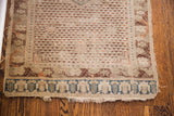 Aged ivory field and blue patterned border of an antique Turkish rug with worn faux fringe.