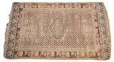 Aged corner of an antique Turkish rug, displaying delicate perimeter and faded traditional motifs.