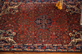 Detail of Vintage Bijar rug with dense cherry red field, classic medallion, and patterned border.
