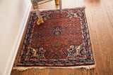 Dense cherry red field with ivory corner spandrel motifs on a Vintage Bijar rug.