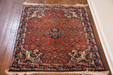 Close-up of vintage Bijar rug's dense weave, colorful border, and worn ivory fringe.