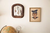 Vintage 1930s arched wall mirror with a dark distressed frame and chippy glass.